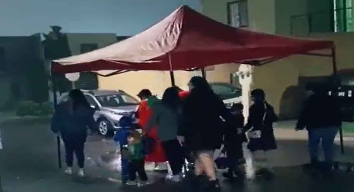 ¡Hay prioridades! Familia saca la lona para pedir calaverita colectiva y no mojarse